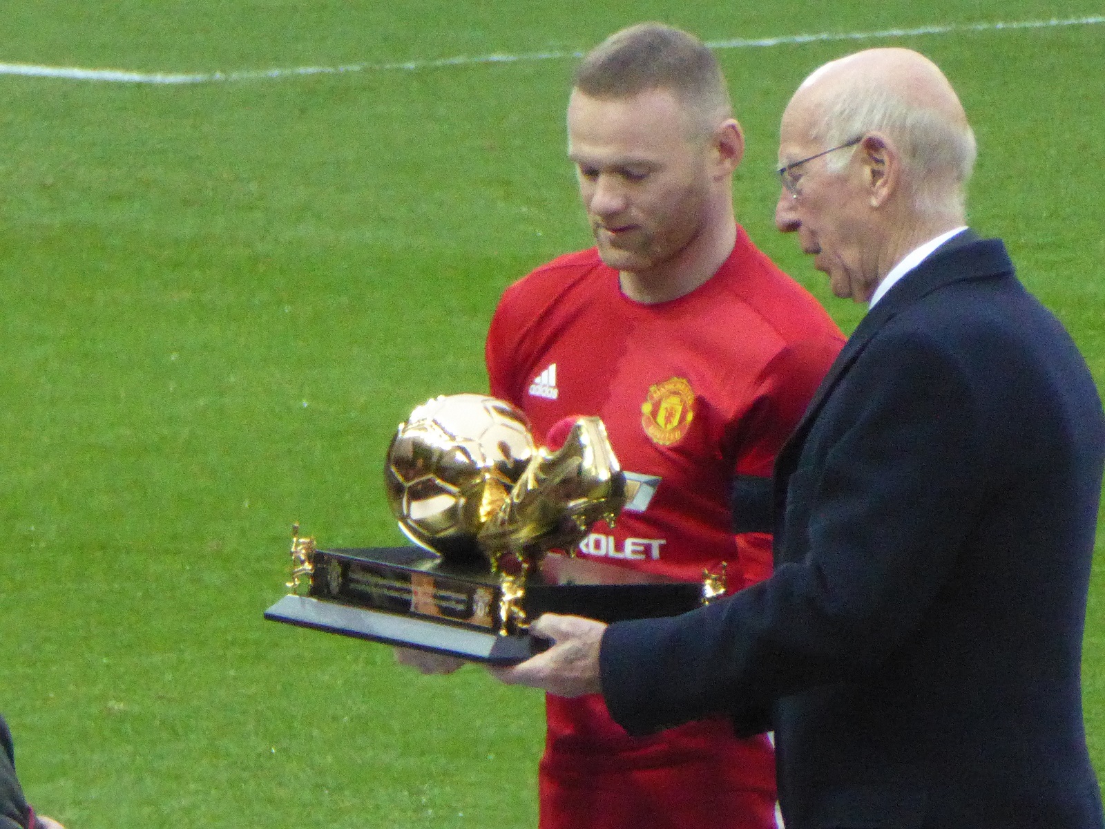 Rooney receiving an award for becoming Manchester United's record goalscorer from previous record holder Sir Bobby Charlton in January 2017
